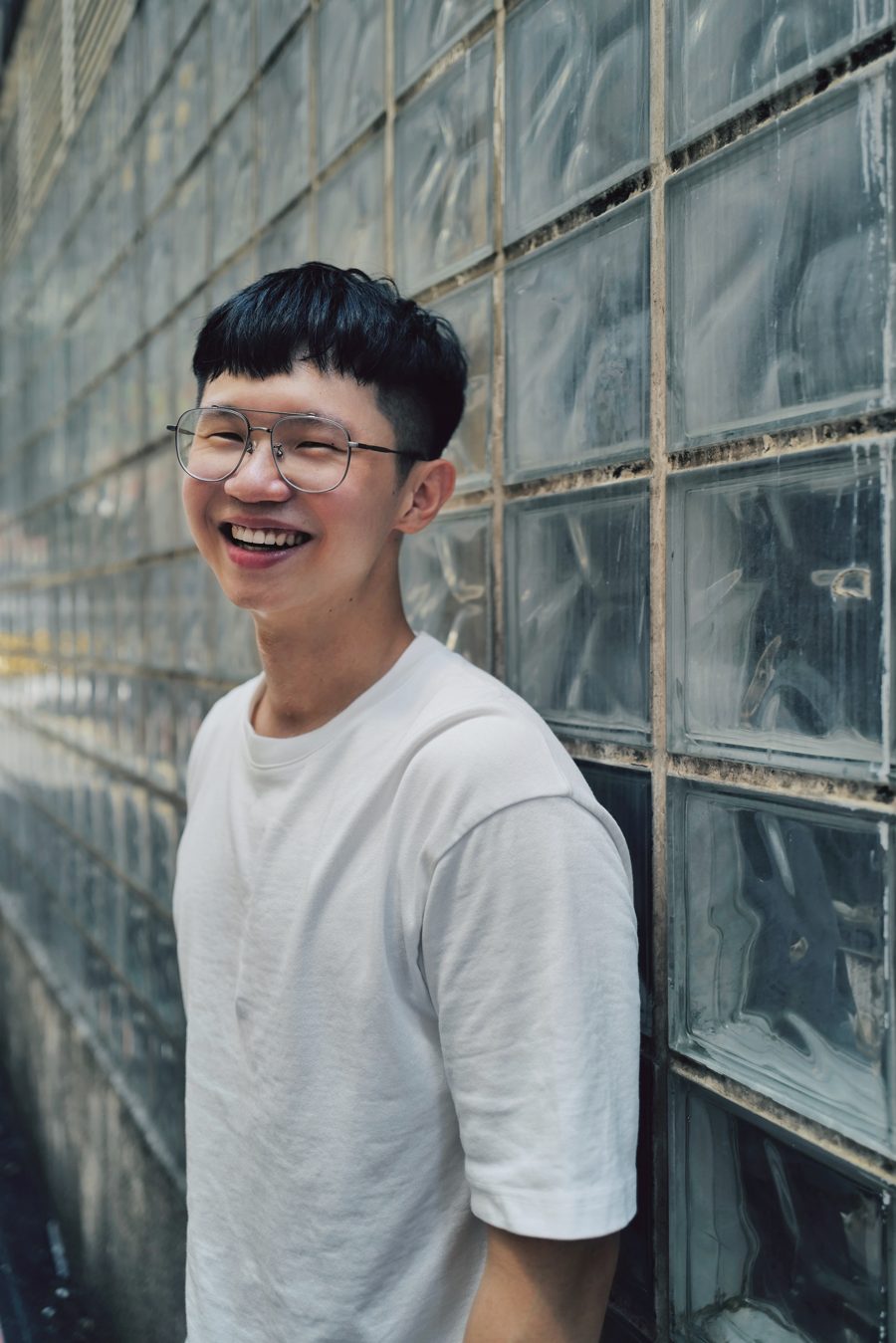 Portrait, laughing, glass-block wall